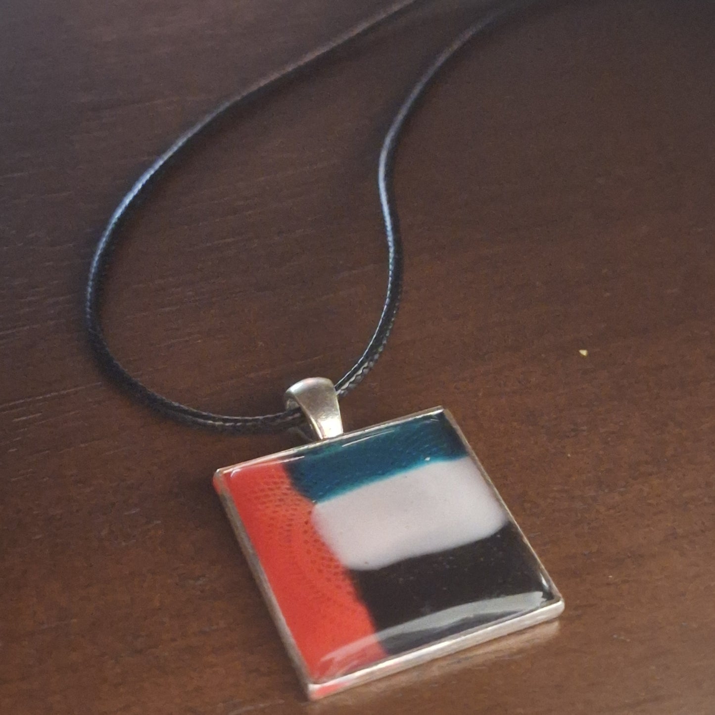 Necklace with a square pendant featuring inspired by UAE flag